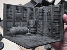Load image into Gallery viewer, A miniature tabletop gaming diorama room built from gray 3D-printed paneling, featuring a cylindrical tank and industrial textures, held by a hand.